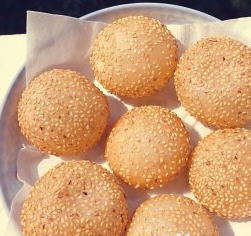 空心麻圆，外形圆圆的、金黄色，外层带有芝麻粒的油炸面食